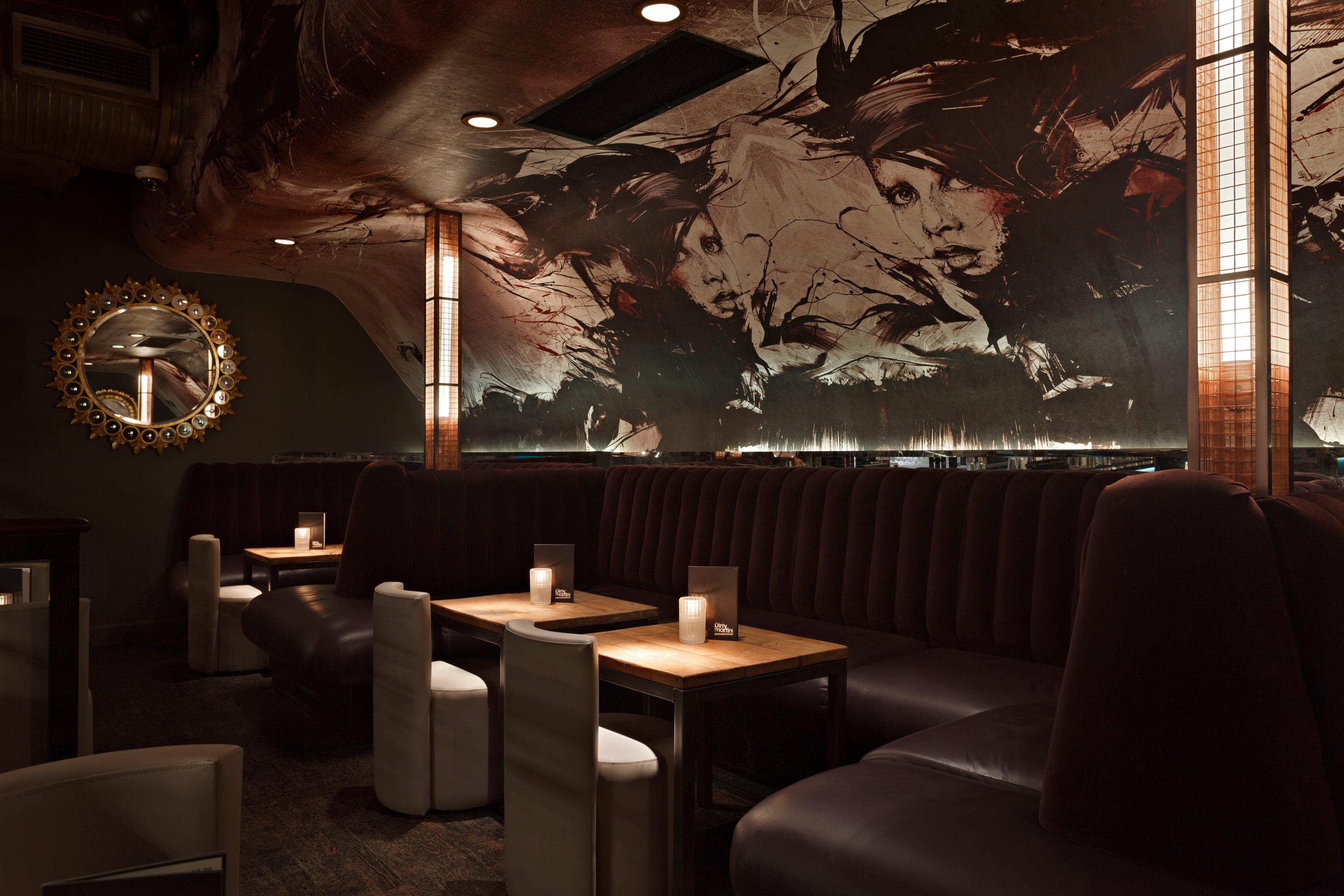 A private hire space with a wall mural and cosy seating in Dirty Martini Covent Garden